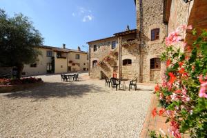a courtyard with tables and chairs in a building at Relais Borgo Torale in Passignano sul Trasimeno