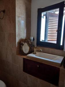 a bathroom with a sink and a mirror at Saint Anna Country House. in Agia Anna