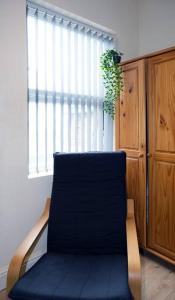 a blue chair in a room with a window at LFC Stadium Apartment 4 in Liverpool