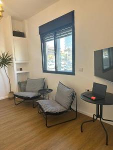 a room with two chairs and a table with a laptop at Central Studio with a Garden in Tel Aviv