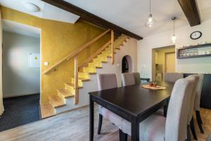 a dining room with a table and chairs and a staircase at Apartmány U Pavla in Český Krumlov