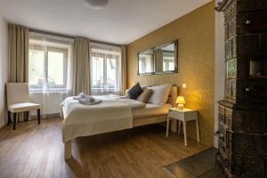 a bedroom with a large bed and two windows at Apartmány U Pavla in Český Krumlov