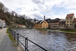 a river in a town with houses and buildings at Apartmány U Pavla in Český Krumlov