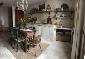 a kitchen with a wooden table and chairs and a table at Borgo Ferracina by BORGHI VENETI in Solagna