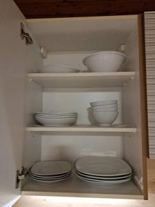 a cabinet with white bowls and plates in it at Ferienwohnung Zanier in Gaißau