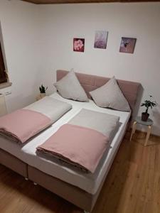 a bed with pink pillows on it in a room at Ferienwohnung Zanier in Gaißau