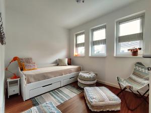 a small bedroom with a bed and two windows at Ferienhaus Zur Oie in Bresewitz