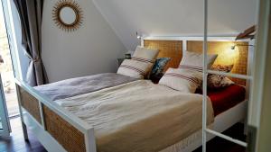 een slaapkamer met een groot bed en een spiegel bij Ferienhaus Zur Oie in Bresewitz