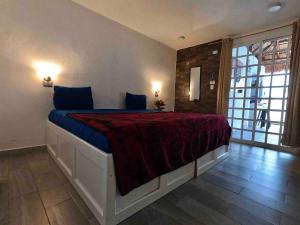 - une chambre avec un grand lit et une couverture rouge dans l'établissement La Perle Noire - Auberge, à Cozumel