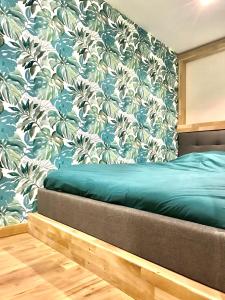 a bedroom with a bed with a floral wallpaper at Les cocons du bassins - Logements neufs tout équipés proche littoral in Gujan-Mestras