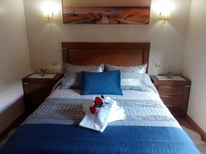 Un dormitorio con una cama azul con un osito de peluche. en El Cameliar - Vibañu, en Vibaño