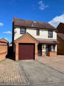 een groot bakstenen huis met een rode garage bij Spacious 10 bed house in Leicester in Leicester