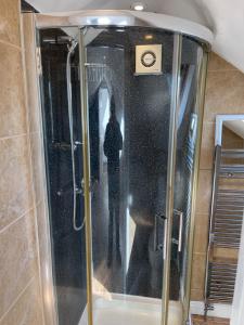 een douche met een glazen deur in de badkamer bij Spacious 10 bed house in Leicester in Leicester