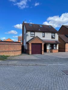 a house with a garage and a brick wall at Spacious 10 bed house in Leicester in Leicester