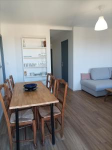 a dining room and living room with a table and chairs at Plein centre, T3, 2ch, balcon et vue in Mèze
