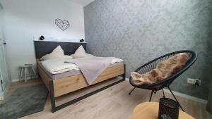 een slaapkamer met een bed en een stoel bij Wilhelms Mitte in Wilhelmshaven