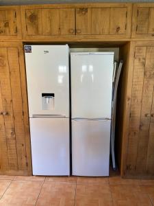 two white refrigerators in a room with wooden cabinets at Spacious 10 bed house in Leicester in Leicester