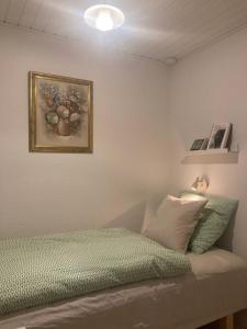 sypialnia z łóżkiem i obrazem na ścianie w obiekcie Skovlyset’s B&B w mieście Juelsminde