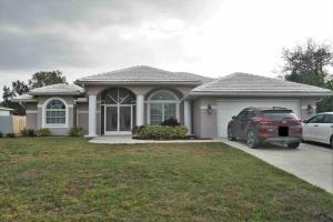 a house with a car parked in front of it at Peachland getaway with heated pool and tiki bar in Port Charlotte