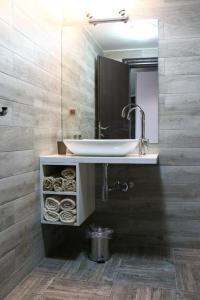 La salle de bains est pourvue d'un lavabo et d'un miroir. dans l'établissement Old Corner apartments Sarajevo, à Sarajevo