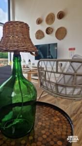 eine grüne Glasflasche mit einer Lampe auf dem Tisch in der Unterkunft Wine House in Altares