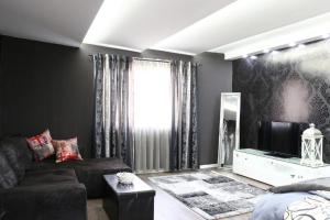 - un salon avec un canapé et une télévision dans l'établissement Old Corner apartments Sarajevo, à Sarajevo