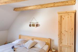 Schlafzimmer mit einem Bett mit einem Kopfteil aus Holz in der Unterkunft Althanský hostinec in Znojmo