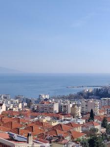 a city with buildings and the ocean in the background at Rafaela's Apartment in Kavala