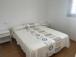 um quarto com uma cama com um cobertor em Piso coqueto Chiclana em Chiclana de la Frontera