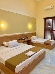 a bedroom with two beds and a window at Kelud Syariah Guesthouse in Blitar