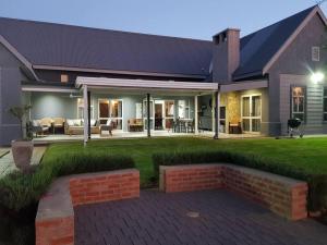 a house with a brick patio and a yard at Dam'n Devine in Parys