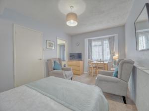 a bedroom with a bed and two chairs and a table at Apartment 8 - Large Studio Sea Front-Ground floor -Free Parking in Paignton