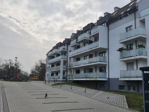 a large white apartment building with a lot of balconies at Apartament Pastelowy in Świnoujście