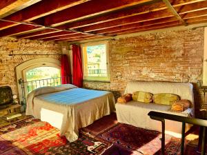 1 dormitorio con 2 camas y pared de ladrillo en Torre Ducale Dimora Storica, en Génova