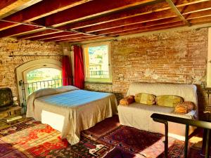 a bedroom with two beds and a brick wall at Torre Ducale Dimora Storica in Genoa