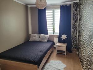Łóżko lub łóżka w pokoju w obiekcie Apartament Palisadowa