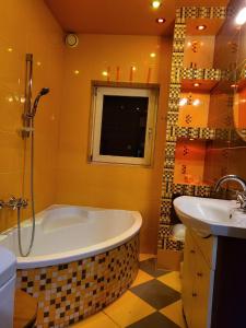 a bathroom with a tub and a sink at Pokoje pracownicze Witkowska in Gniezno