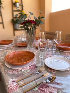 une table avec des assiettes et des verres et un vase avec des fleurs dans l'établissement Casa Azahar, à Tarifa