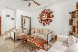 a living room with white furniture and a clock on the wall at Private Tulum Villa in Exclusive Secured Community in Tulum