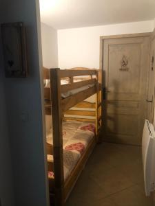 two bunk beds in a room with a door at Ma tanière aux 7 Laux in Les Adrets