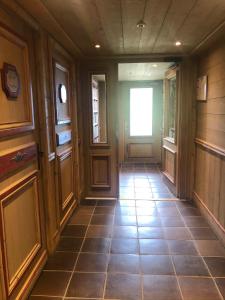 a hallway with a door and a tile floor at Ma tanière aux 7 Laux in Les Adrets