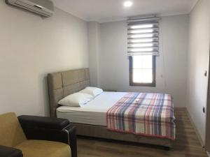 a bedroom with a bed and a chair and a window at seyran 3 in Trabzon
