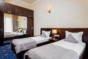 a hotel room with two beds and a bathroom at Amberd Hotel in Byurakan