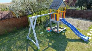 a playground with a slide in a yard at Noclegi, pokoje na Piaskach in Krynica Morska