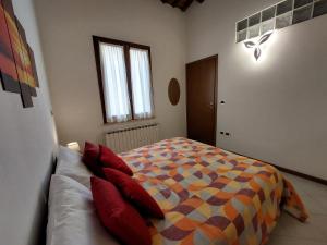 um quarto com uma cama com almofadas vermelhas em Appartamento IN CENTRO Free Wi-Fi, Self check-in em Forlì