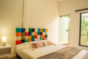 Bett mit farbenfrohem Kopfteil in einem Zimmer in der Unterkunft FLAWLESS LODGE EN IMBANACO, Cali-Colombia in Cali