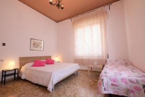 een slaapkamer met 2 bedden en een raam met roze kussens bij Orchidea PT - Pineto Vacanza in Pineto