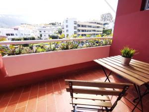 balcón con mesa de madera y banco en Hotel Don Cándido en Puerto de la Cruz