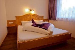 a bed with white sheets and pillows in a room at Alexandra's Apartment in Neustift im Stubaital