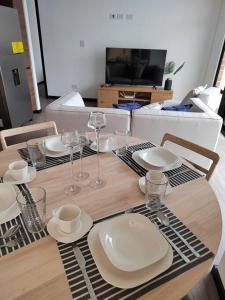 a table with plates and wine glasses on it at Hermoso apartamento nuevo en zona 10! in Guatemala